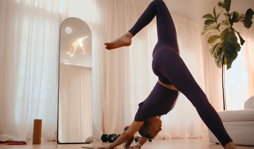 Woman in front of an AlterMe mirror in a yoga pose